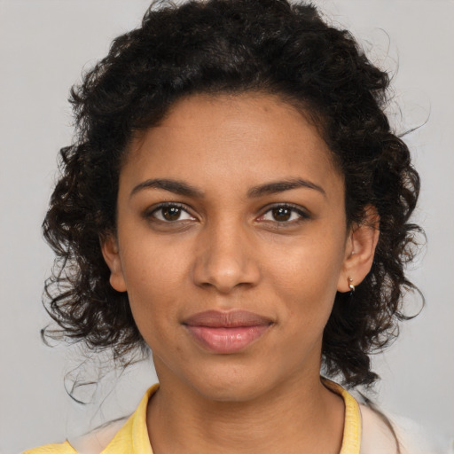 Joyful black young-adult female with medium  brown hair and brown eyes