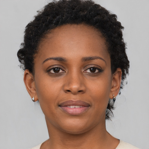 Joyful black young-adult female with short  brown hair and brown eyes