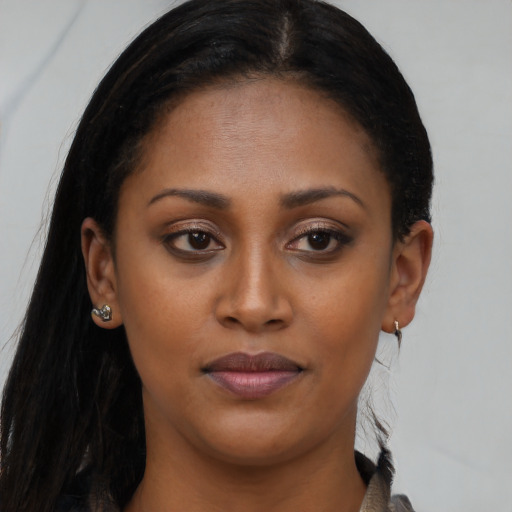 Joyful black young-adult female with long  brown hair and brown eyes