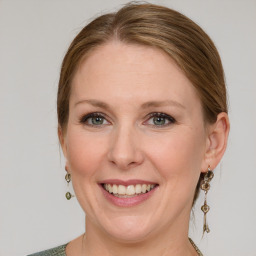 Joyful white adult female with medium  brown hair and blue eyes