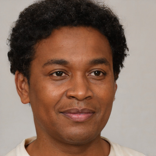 Joyful black young-adult male with short  brown hair and brown eyes