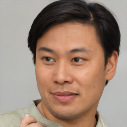 Joyful asian young-adult male with short  brown hair and brown eyes