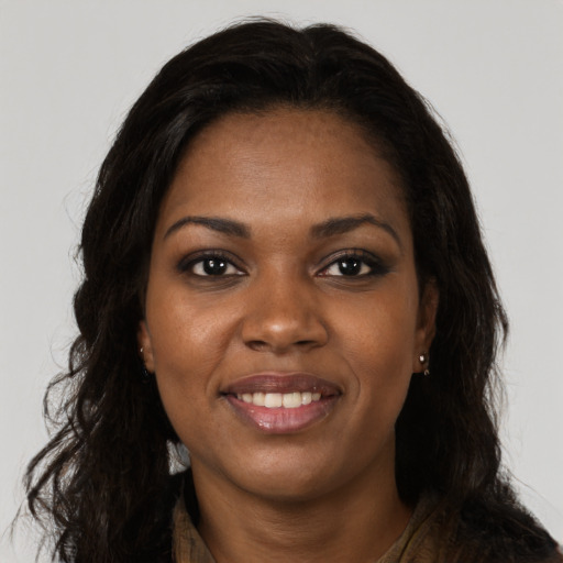 Joyful black young-adult female with long  brown hair and brown eyes