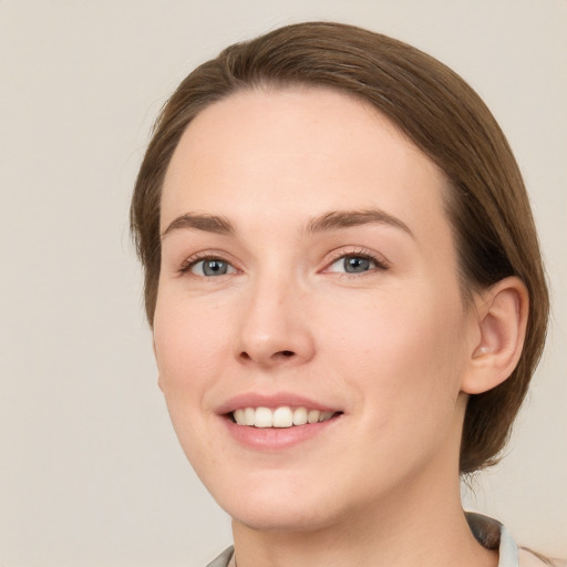 Joyful white young-adult female with medium  brown hair and green eyes