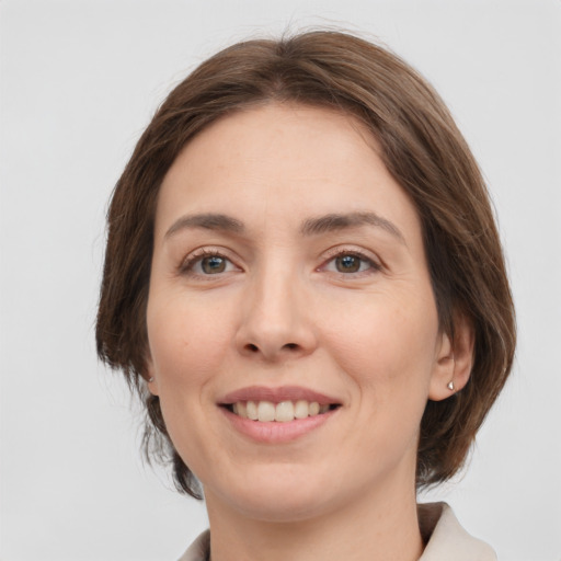 Joyful white young-adult female with medium  brown hair and green eyes