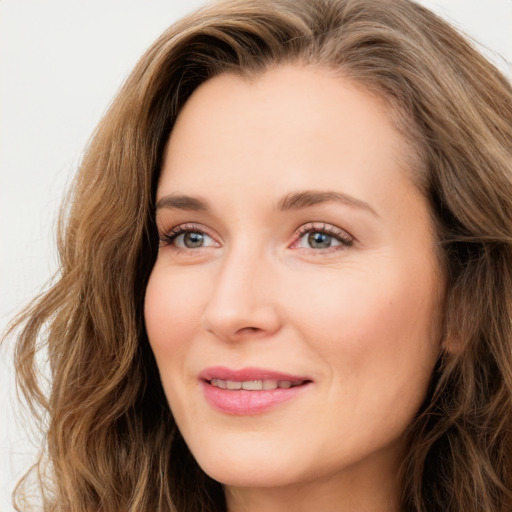 Joyful white young-adult female with long  brown hair and green eyes