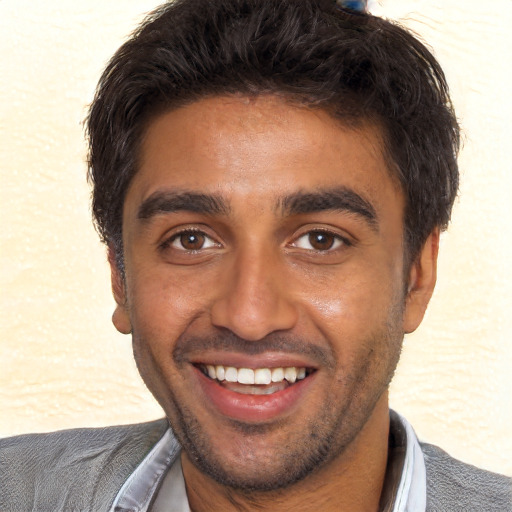 Joyful black young-adult male with short  brown hair and brown eyes