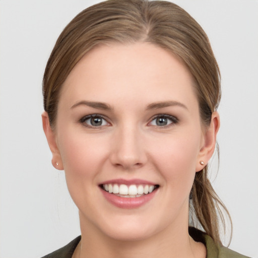 Joyful white young-adult female with medium  brown hair and grey eyes