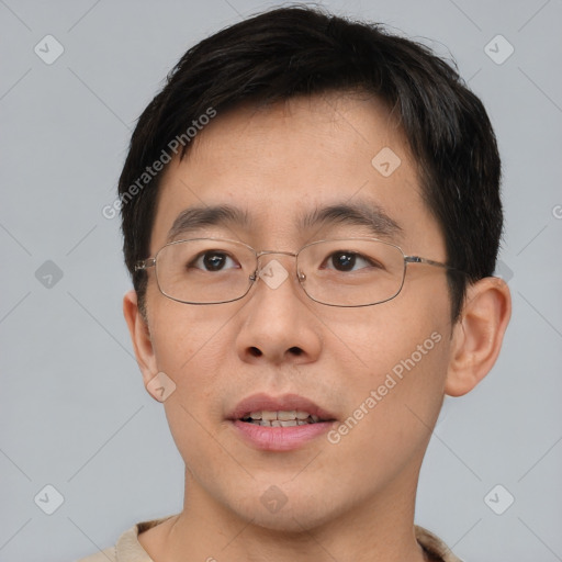 Joyful asian young-adult male with short  brown hair and brown eyes