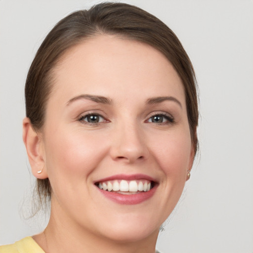 Joyful white young-adult female with medium  brown hair and grey eyes