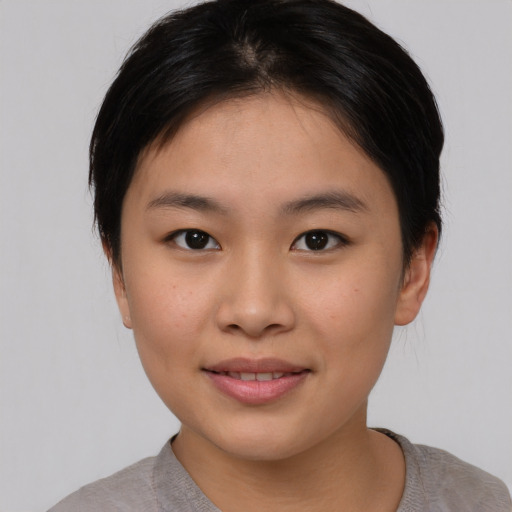 Joyful asian young-adult female with short  brown hair and brown eyes