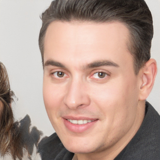 Joyful white young-adult male with short  brown hair and brown eyes