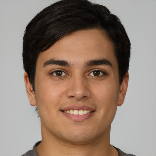 Joyful latino young-adult male with short  brown hair and brown eyes