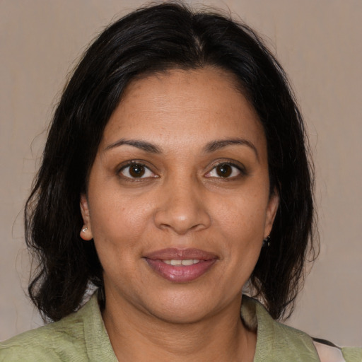 Joyful black adult female with medium  brown hair and brown eyes
