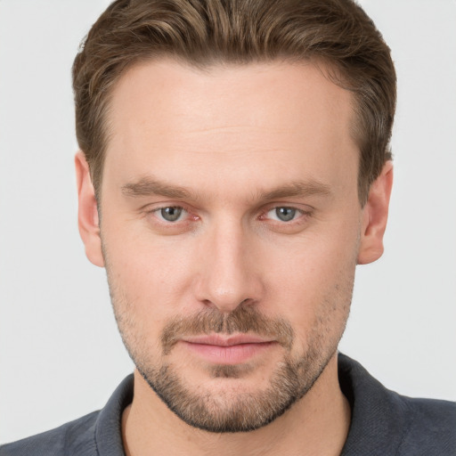 Joyful white young-adult male with short  brown hair and grey eyes