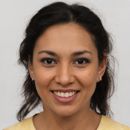 Joyful latino young-adult female with medium  brown hair and brown eyes