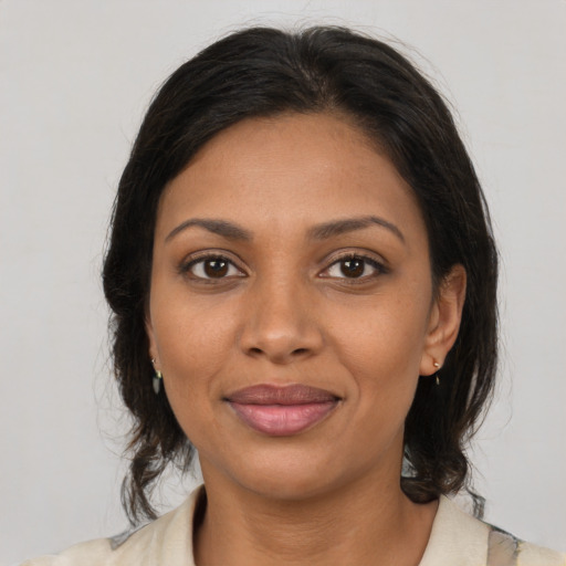 Joyful black young-adult female with medium  brown hair and brown eyes