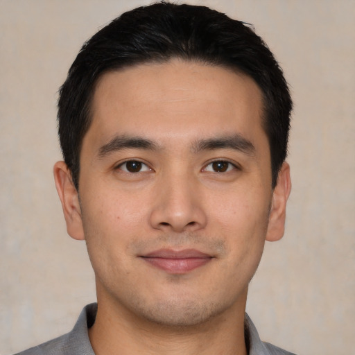 Joyful asian young-adult male with short  black hair and brown eyes