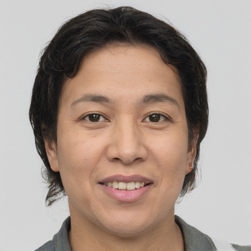 Joyful asian adult female with medium  brown hair and brown eyes