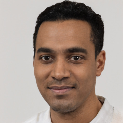 Joyful black young-adult male with short  black hair and brown eyes