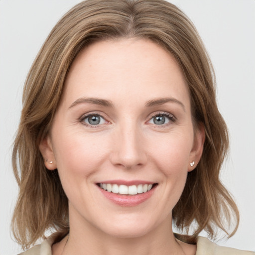 Joyful white young-adult female with medium  brown hair and blue eyes