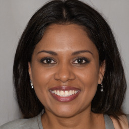 Joyful black young-adult female with medium  brown hair and brown eyes