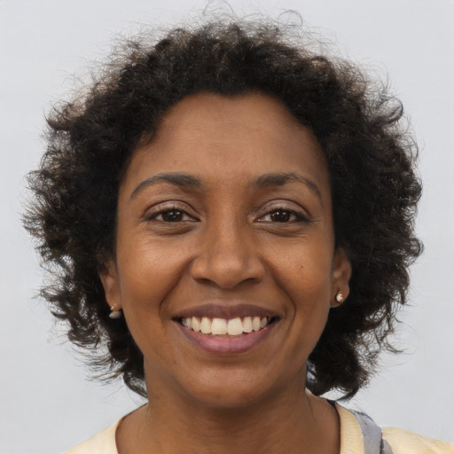 Joyful black young-adult female with short  brown hair and brown eyes