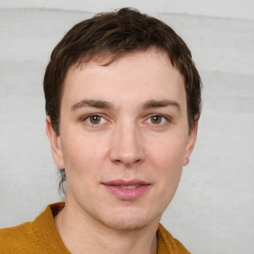 Joyful white young-adult male with short  brown hair and grey eyes