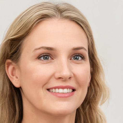 Joyful white young-adult female with long  brown hair and blue eyes