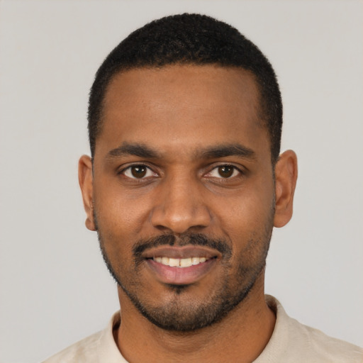 Joyful black young-adult male with short  black hair and brown eyes