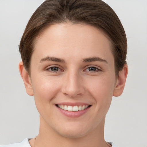 Joyful white young-adult female with short  brown hair and grey eyes