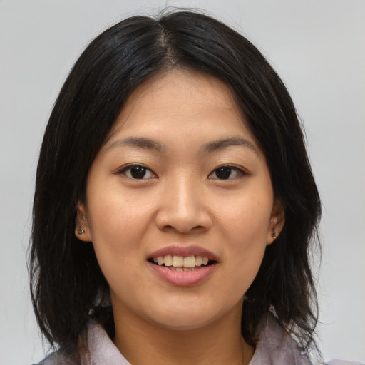 Joyful asian young-adult female with medium  brown hair and brown eyes