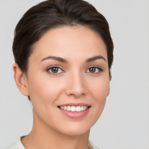 Joyful white young-adult female with short  brown hair and brown eyes