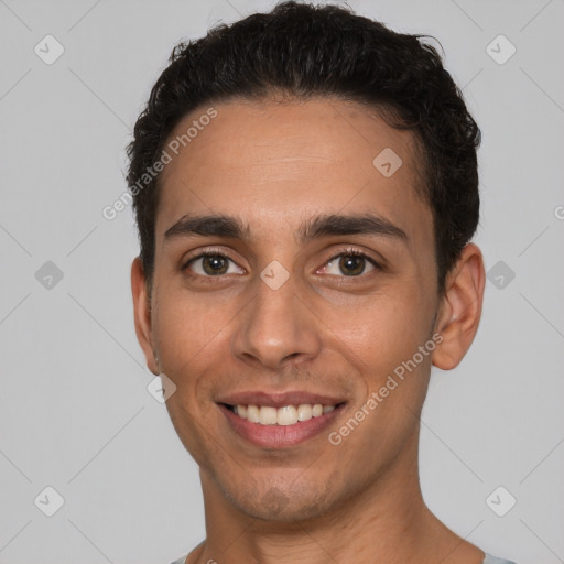 Joyful white young-adult male with short  black hair and brown eyes