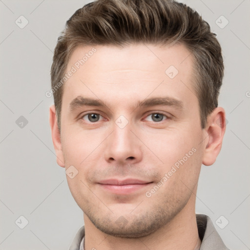 Joyful white young-adult male with short  brown hair and grey eyes