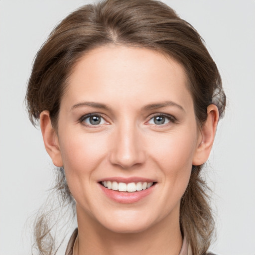 Joyful white young-adult female with medium  brown hair and grey eyes