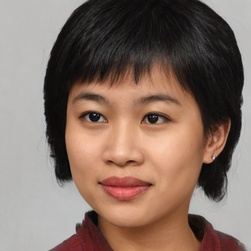 Joyful asian young-adult female with medium  black hair and brown eyes