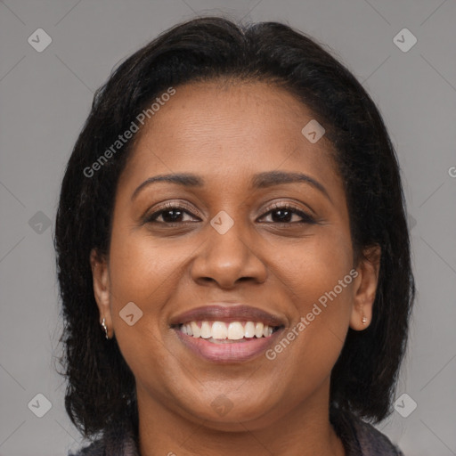 Joyful black young-adult female with long  brown hair and brown eyes