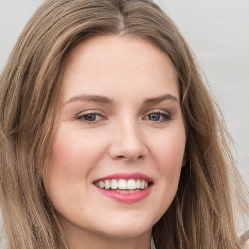 Joyful white young-adult female with long  brown hair and grey eyes