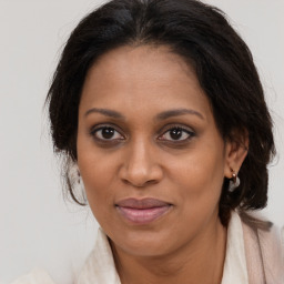 Joyful black adult female with long  brown hair and brown eyes