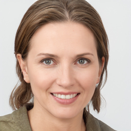 Joyful white young-adult female with medium  brown hair and grey eyes