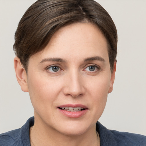 Joyful white young-adult female with short  brown hair and grey eyes