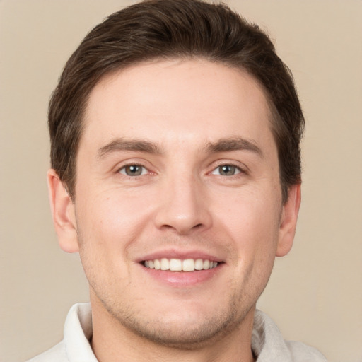 Joyful white young-adult male with short  brown hair and grey eyes