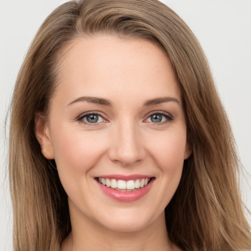 Joyful white young-adult female with long  brown hair and grey eyes