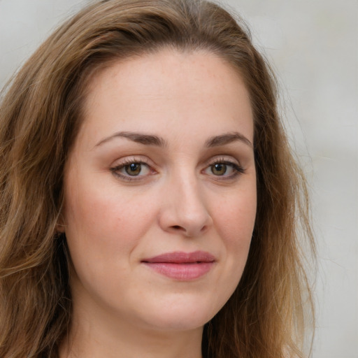 Joyful white young-adult female with long  brown hair and green eyes