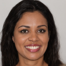 Joyful latino young-adult female with long  brown hair and brown eyes