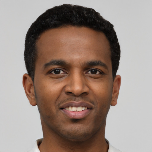 Joyful black young-adult male with short  black hair and brown eyes
