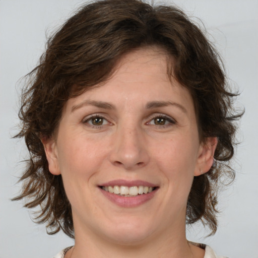 Joyful white young-adult female with medium  brown hair and green eyes