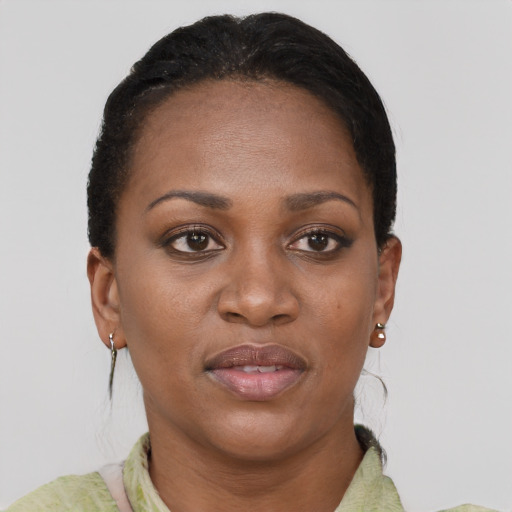 Joyful black young-adult female with short  black hair and brown eyes