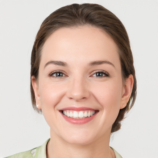 Joyful white young-adult female with medium  brown hair and grey eyes